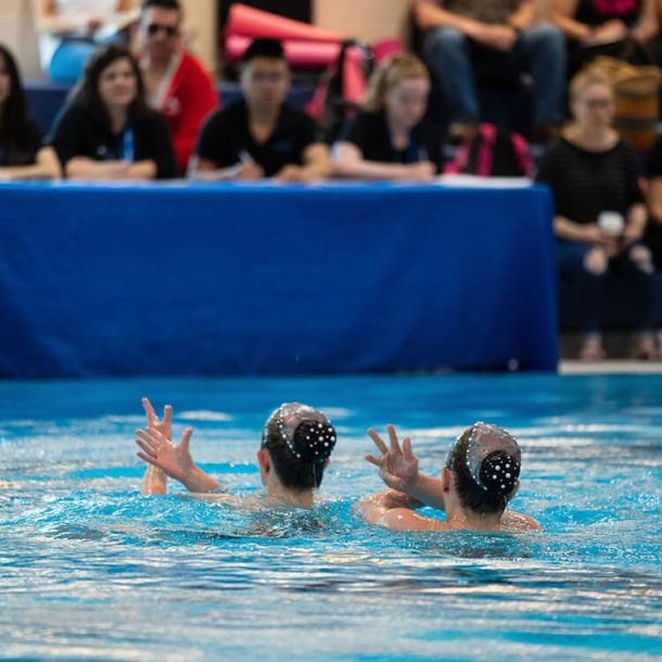 Duo of waterdancer girls in the pool doing routine, aquago program