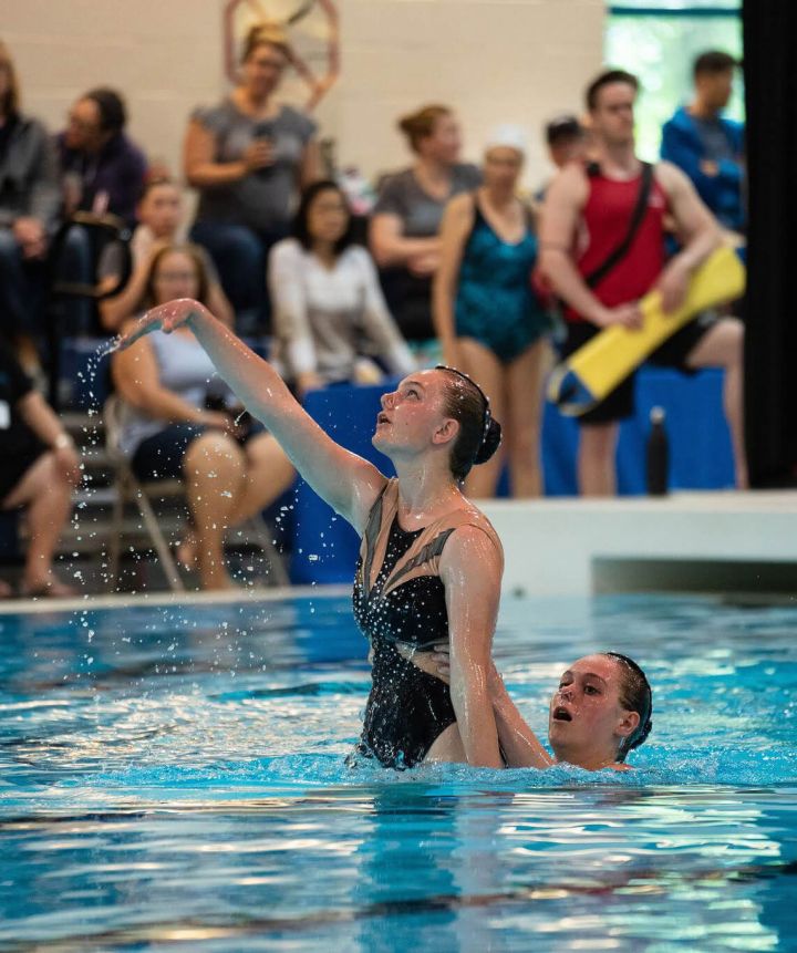 Ravensong Waterdancer hoisting member out of the water with crowd watching behind them