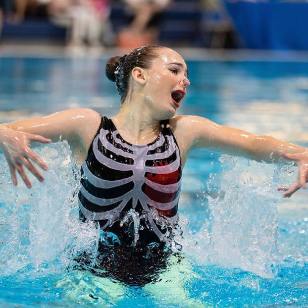 Waterdancer in the pool doing routine, photo signifies all artistic swimming programs