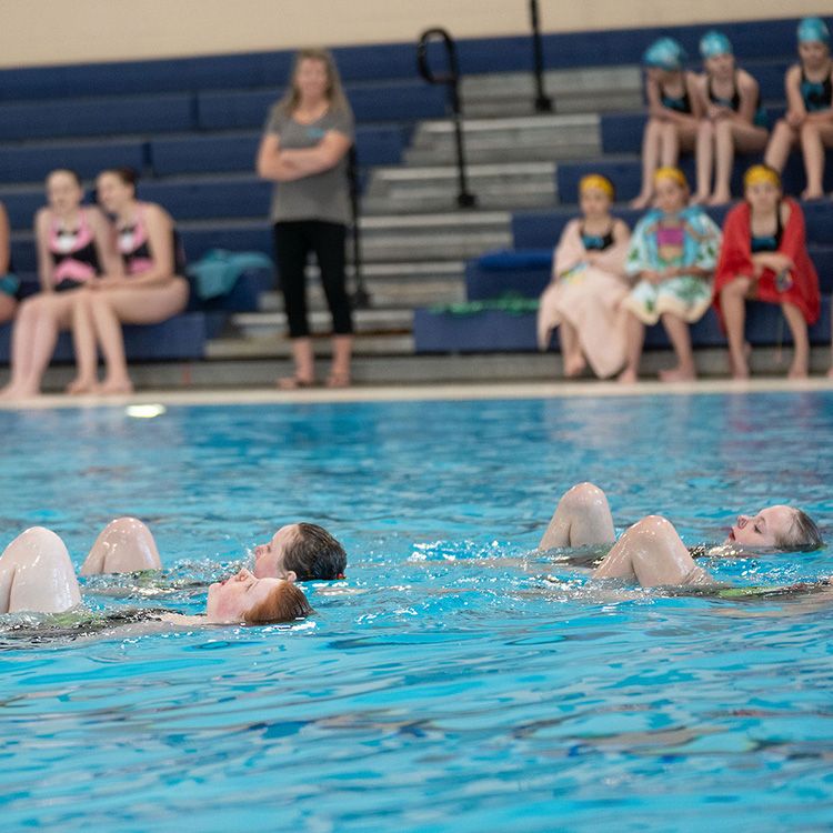 Group of artistic swimmers under water doing routine
