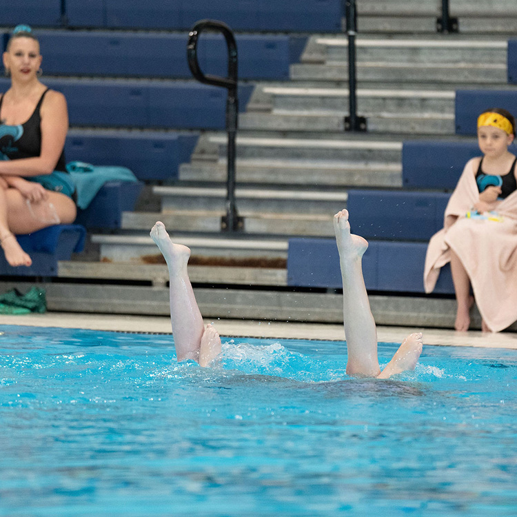 Girls finishing their artistic swimming routine in the pool